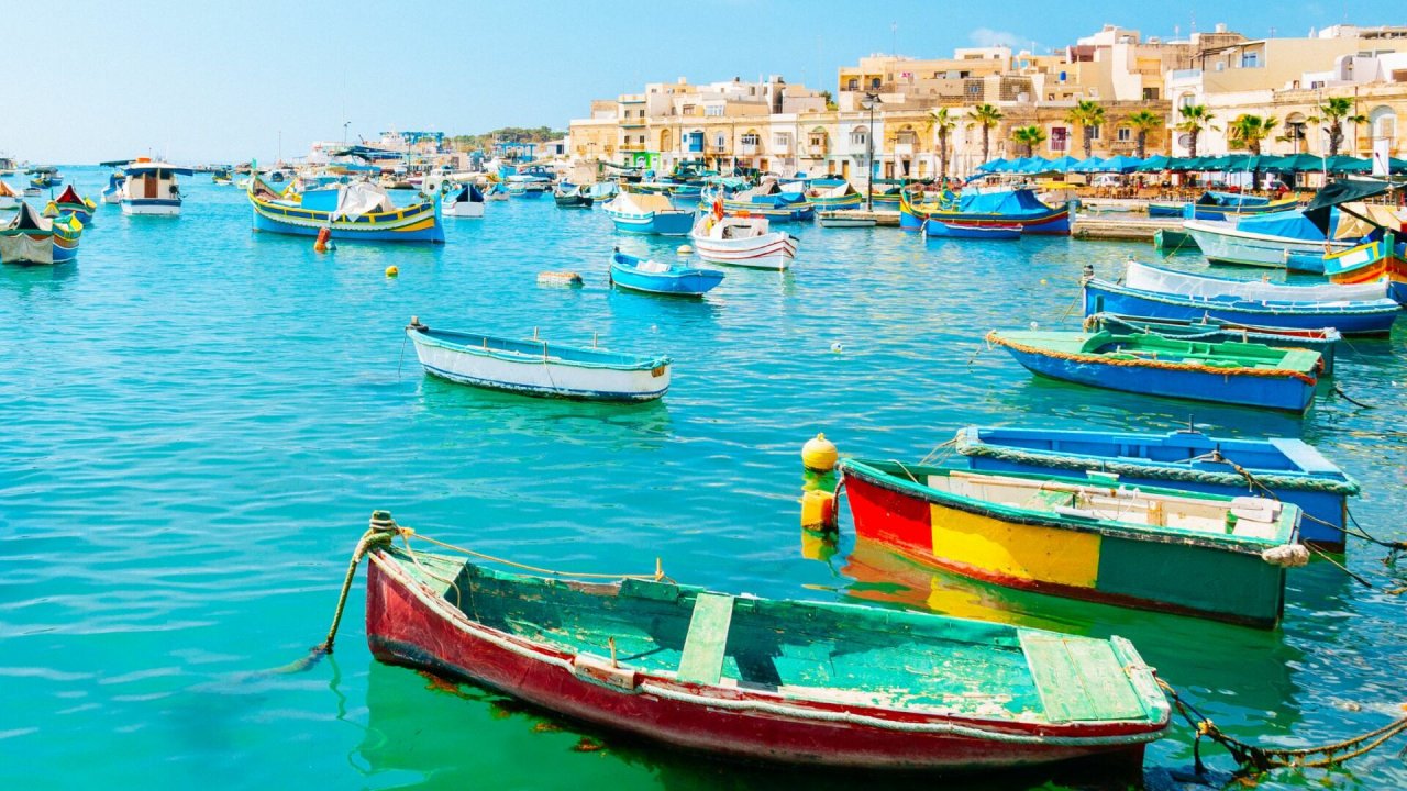 Widok na zacumowane kolorowe łódki w porcie na Malcie