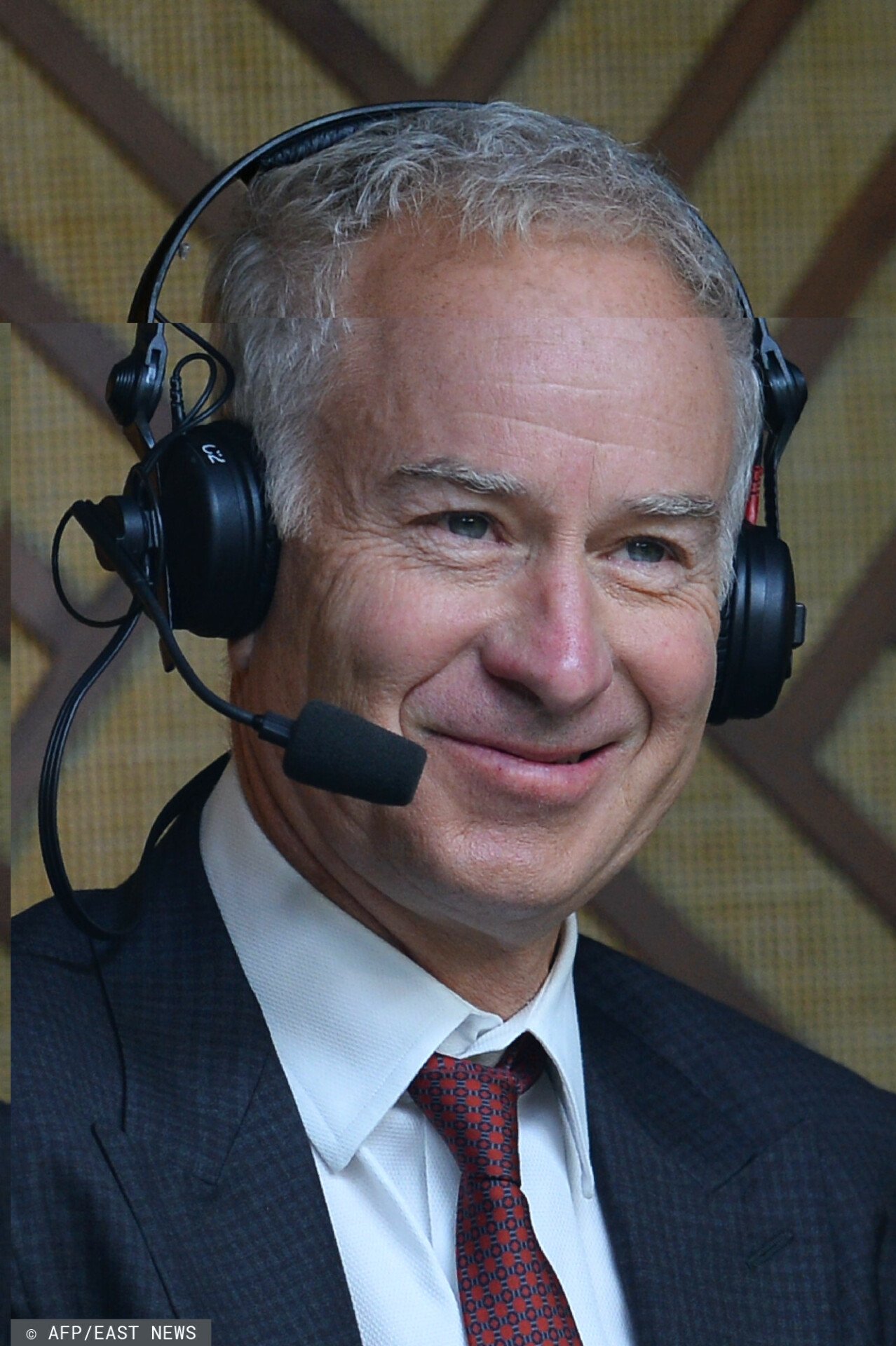 John McEnroe w słuchawkach komentatorskich z mikrofonem