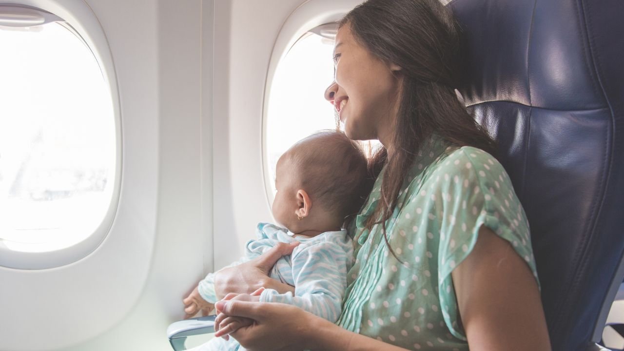 kobieta z niemowlakiem na kolanach w samolocie