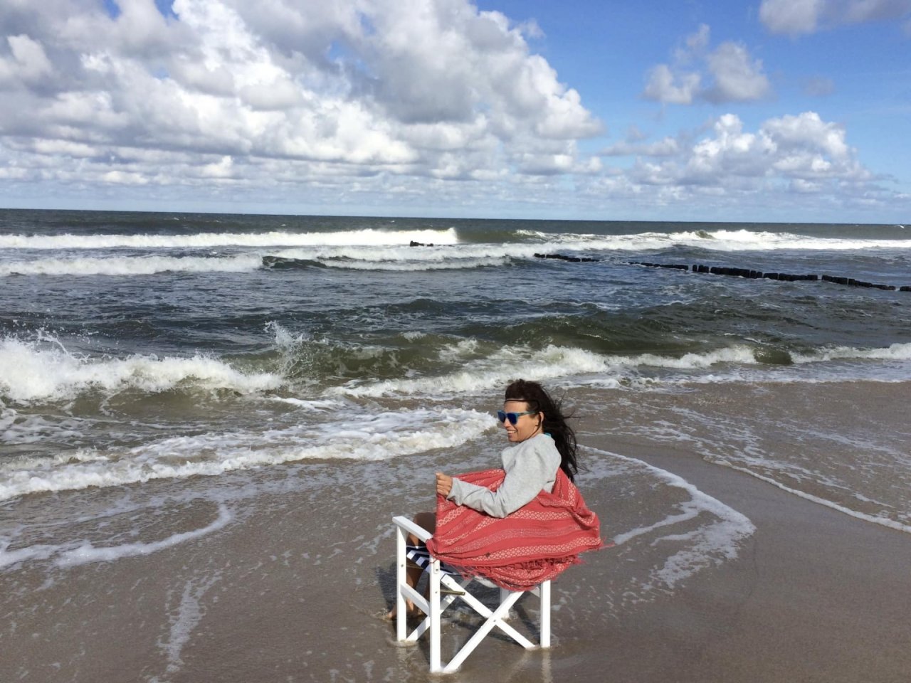 Anna Skrobiszewska na białym drewnianym krzesełku nad brzegiem Bałtyku