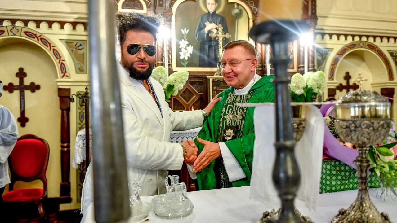 Krzysztof Rutkowski w blasku fleszy poświęcił auta. Nawet pozował z księdzem przy ołtarzu