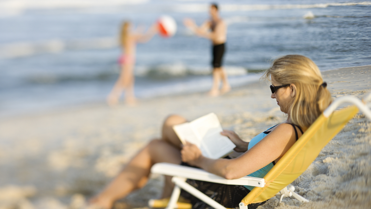 Kobieta z książką na plaży