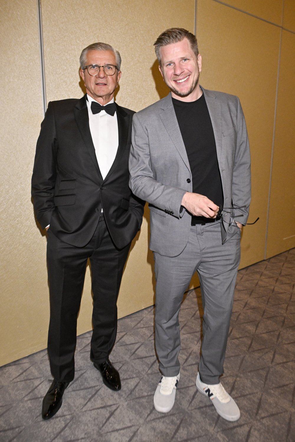 Zygmunt Chajzer w czarnym garniturze i Filip Chajzer w szarej marynarce