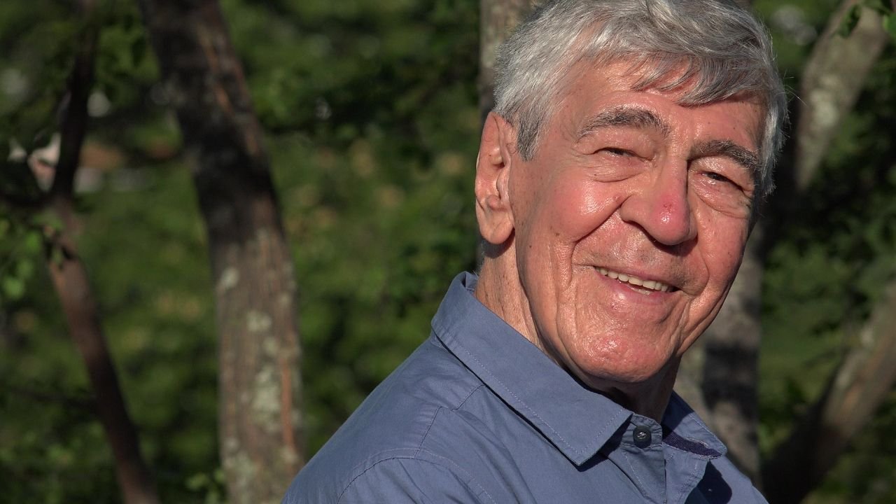 Starszy, uśmiechnięty mężczyzna.