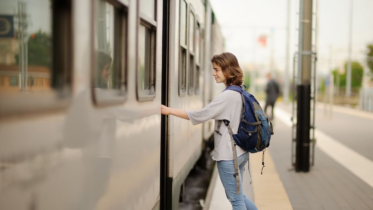 kobieta otwiera drzwi pociągu