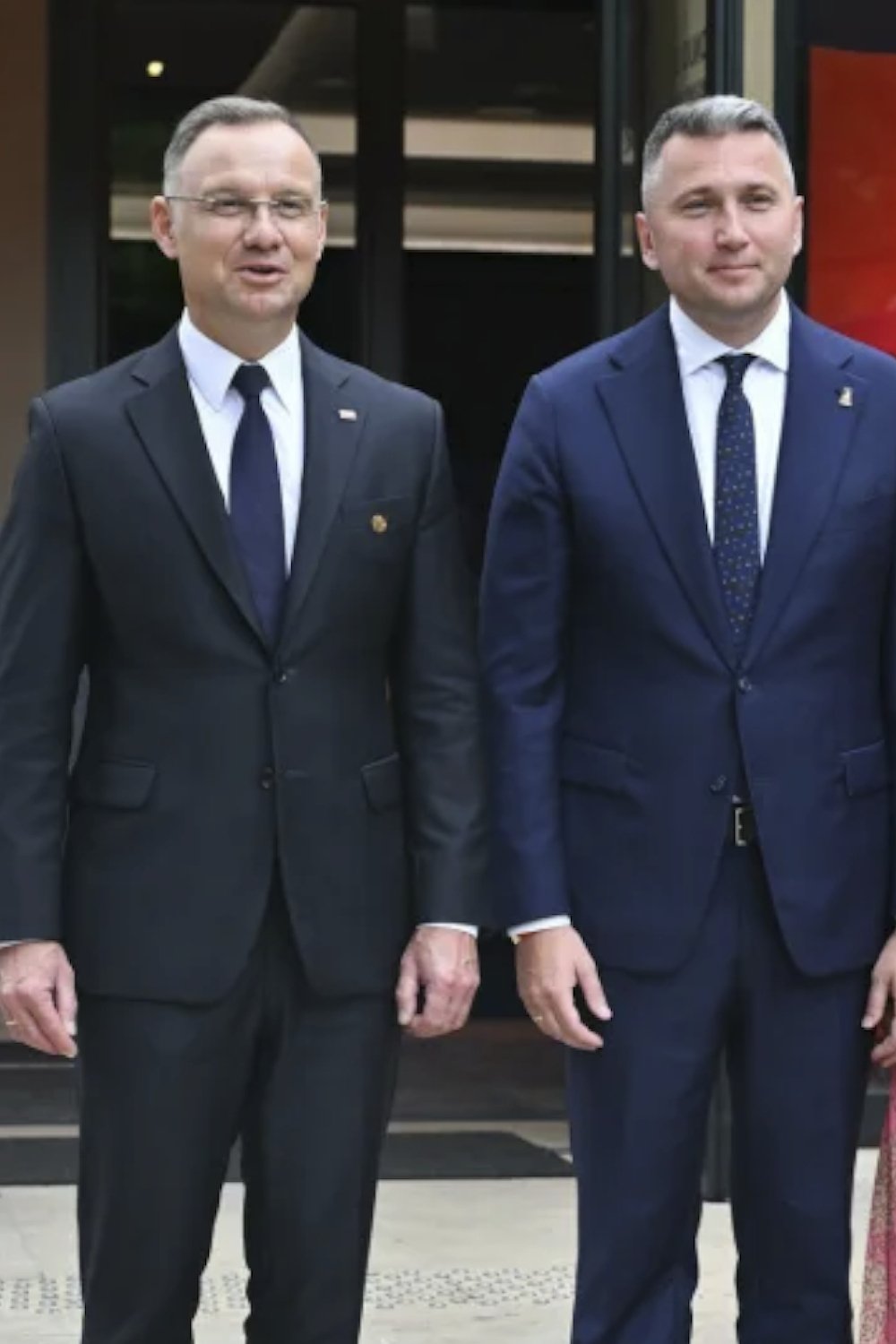 Radosław Piesiewicz w garniturze stojący obok prezydenta Andrzeja Dudy 