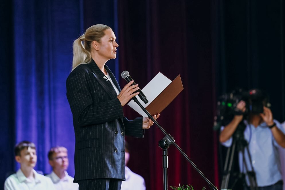 Barbara Nowacka w męskim garniturze przy mównicy