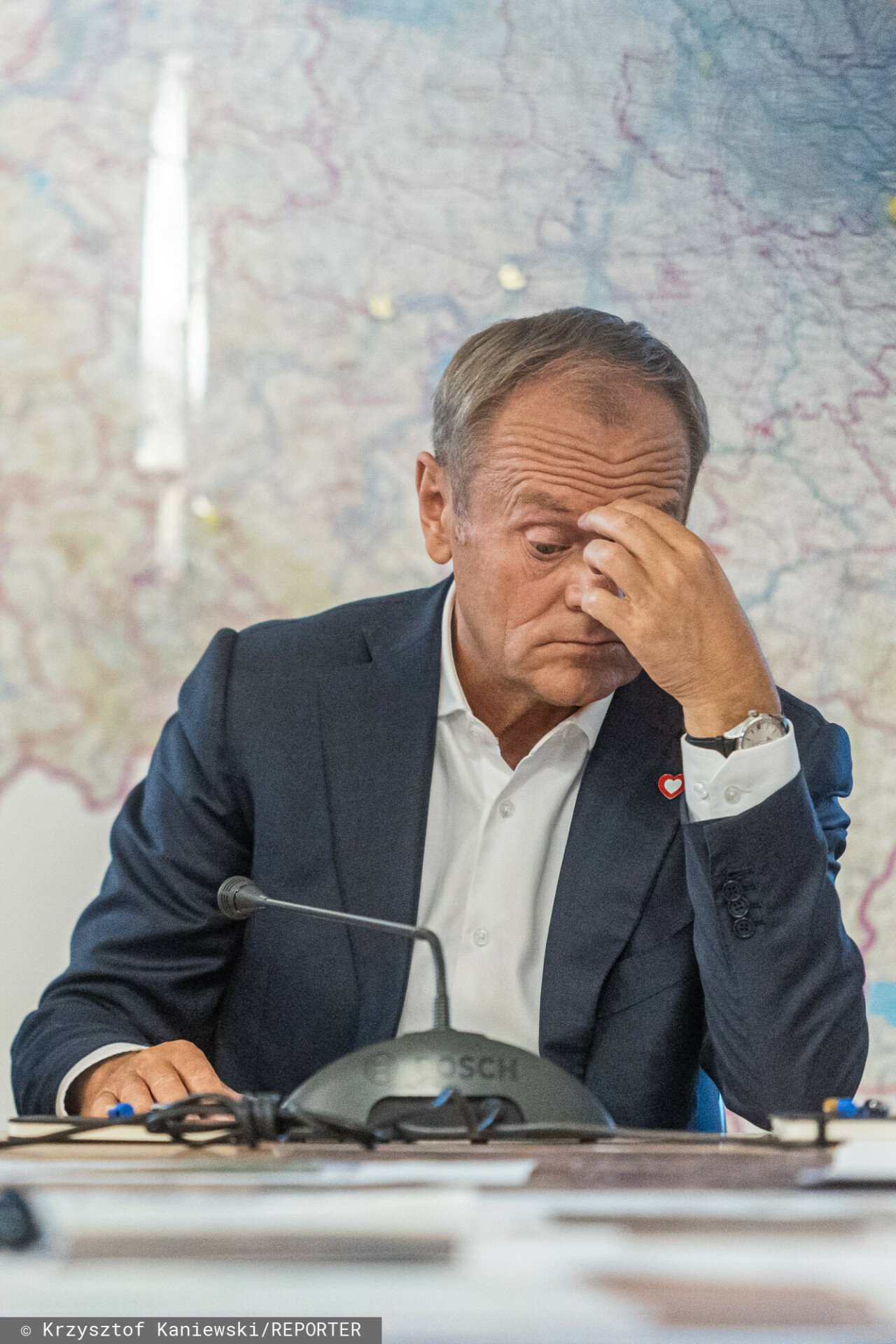 Donald Tusk w garniturze i białej bluzce