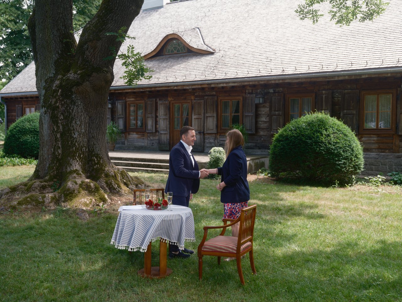 Mężczyzna w garniturze wita się z kobietą