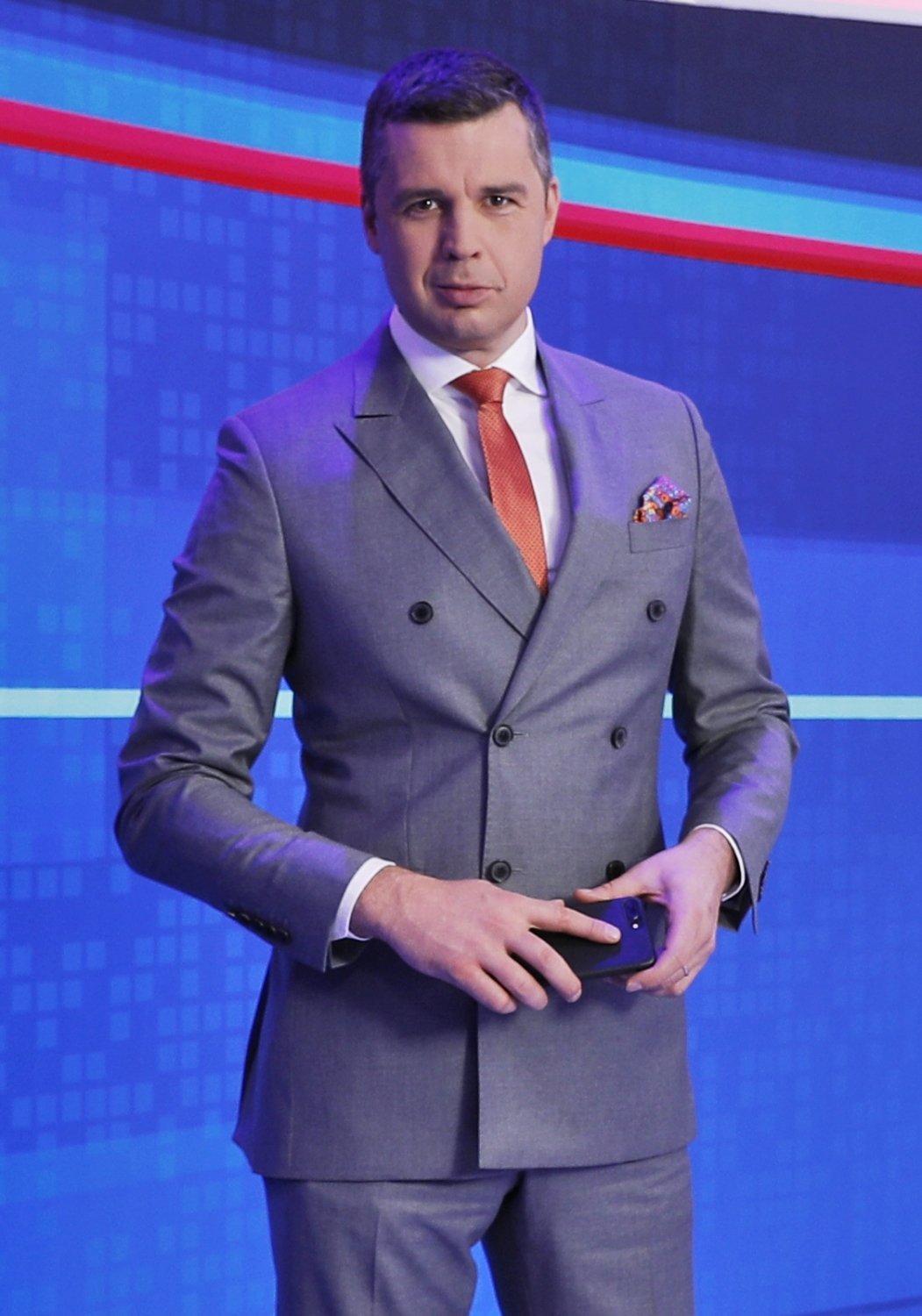 Michał Rachoń w szarym garniturze w studio TVP Info