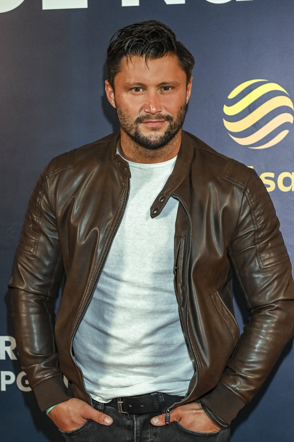 Piotr Mróz w brązowej kurtce i białej koszuli