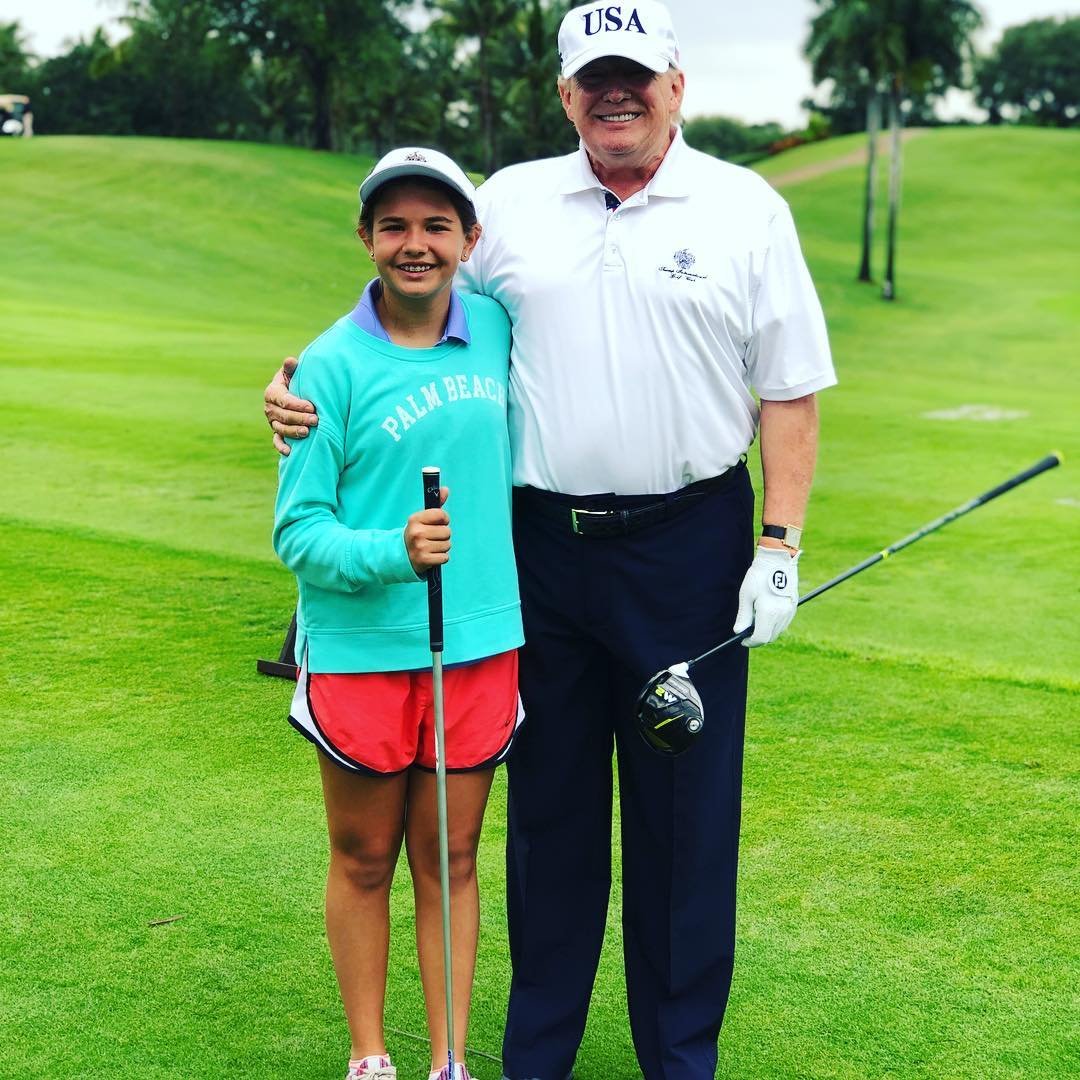 donald trump i jego wnuczka na polu golfowym