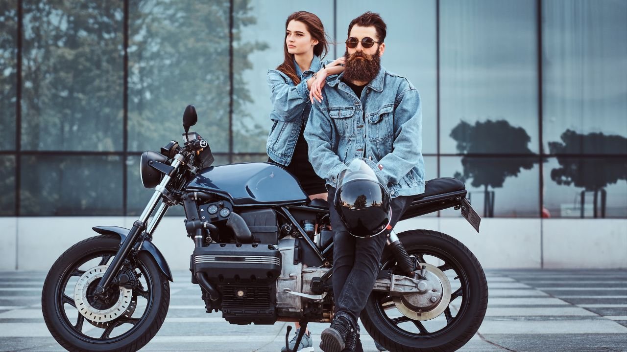 Mężczyzna z broda i kobieta w dżinsowych ciuchach siedzą na motocyklu