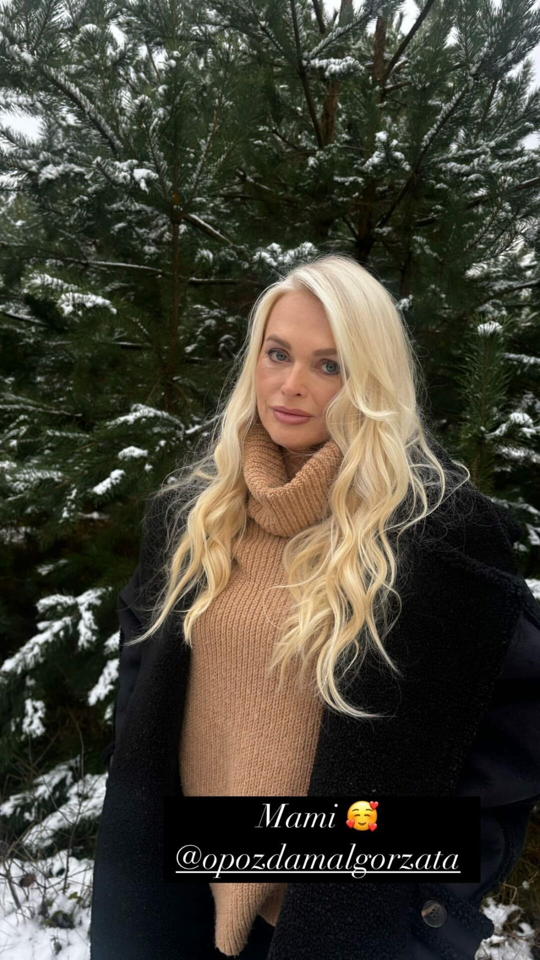 Mama Joanny Opozdy, Małgorzata Opozda, w beżowym golfie i czarnym płaszczu w zimowej scenerii