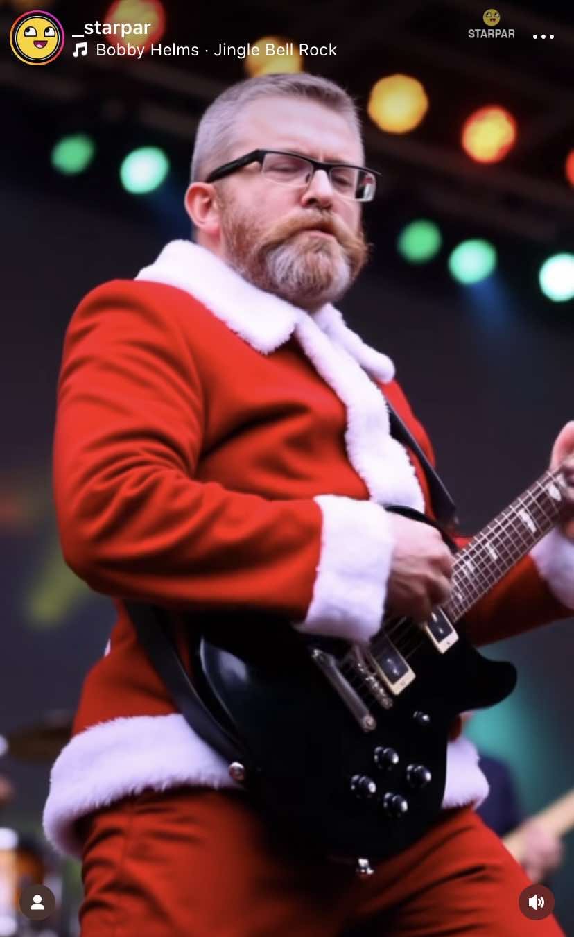 Grzegorz Braun w stroju Mikołaja gra na gitarze