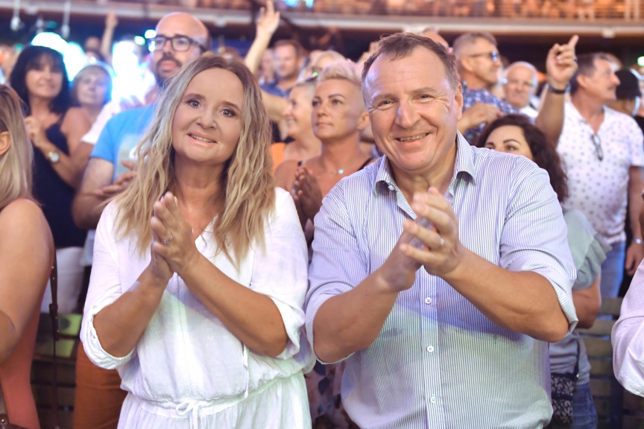 Joanna Kurska w blond włosach obok Jacek Kurski w koszuli klaszczą