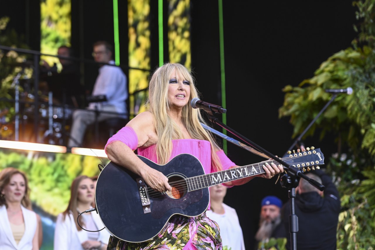 Maryla Rodowicz w różowej bluzce trzyma gitarę