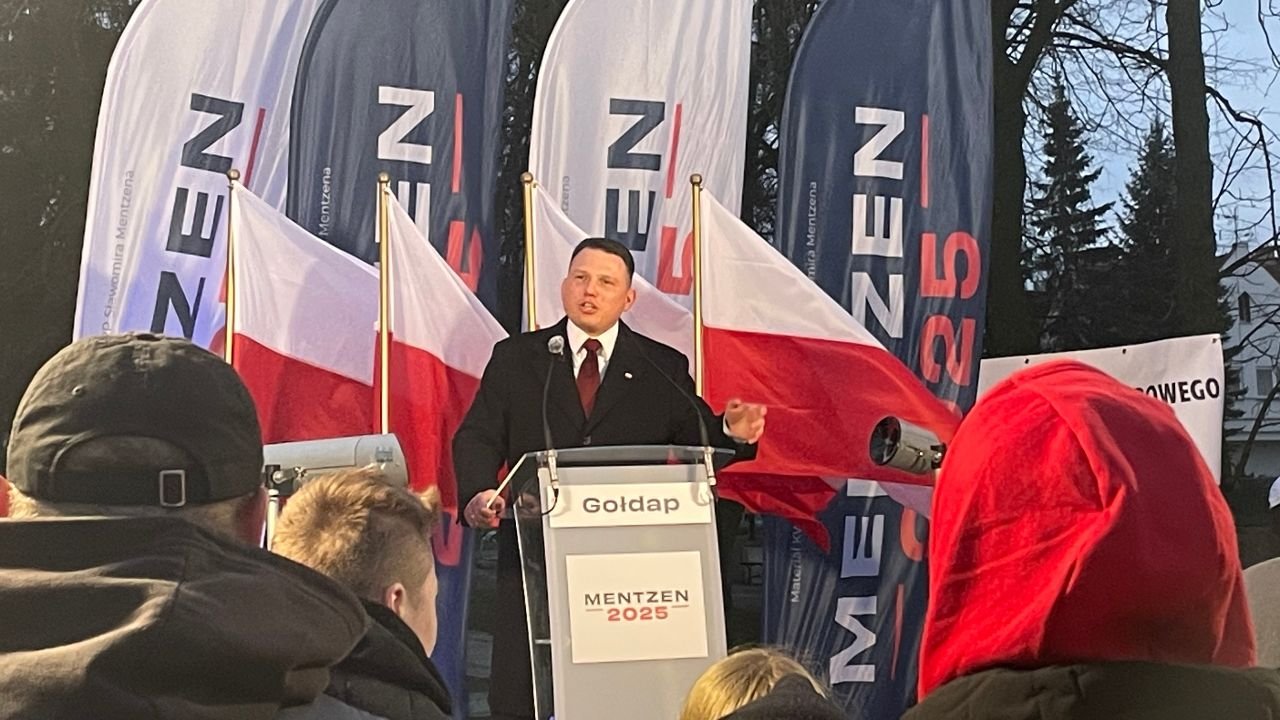 Sławomir Mentzen w czarnym płaszczu przemawia w Gołdapi