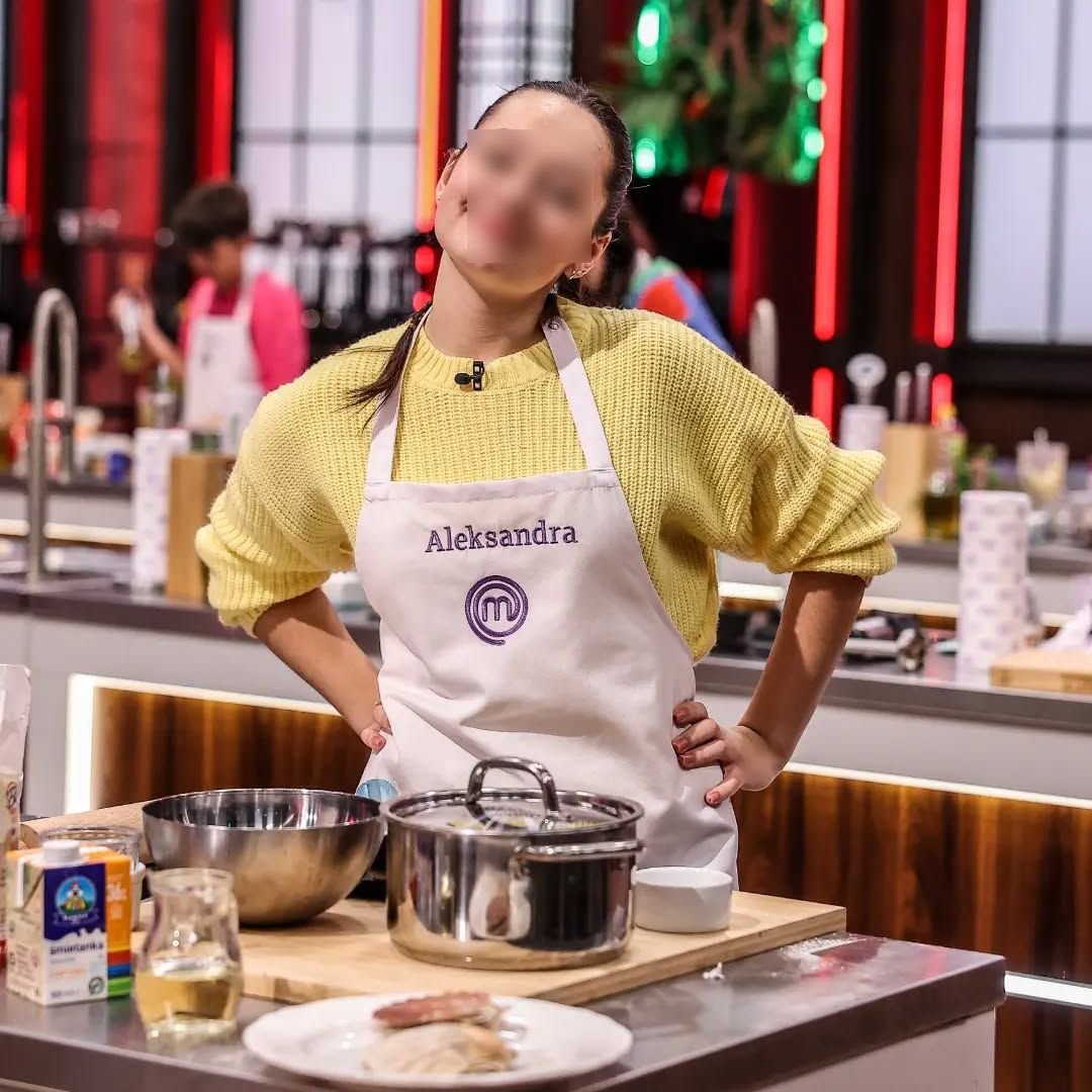 Ola S. w żółtym swetrze i fartuchu z imieniem Aleksandra
