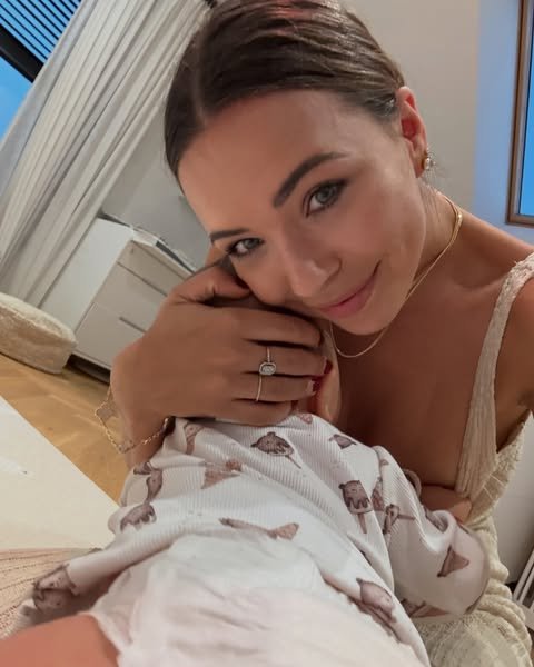 Kubicka w koszulce na ramiączkach przytula synka w domu