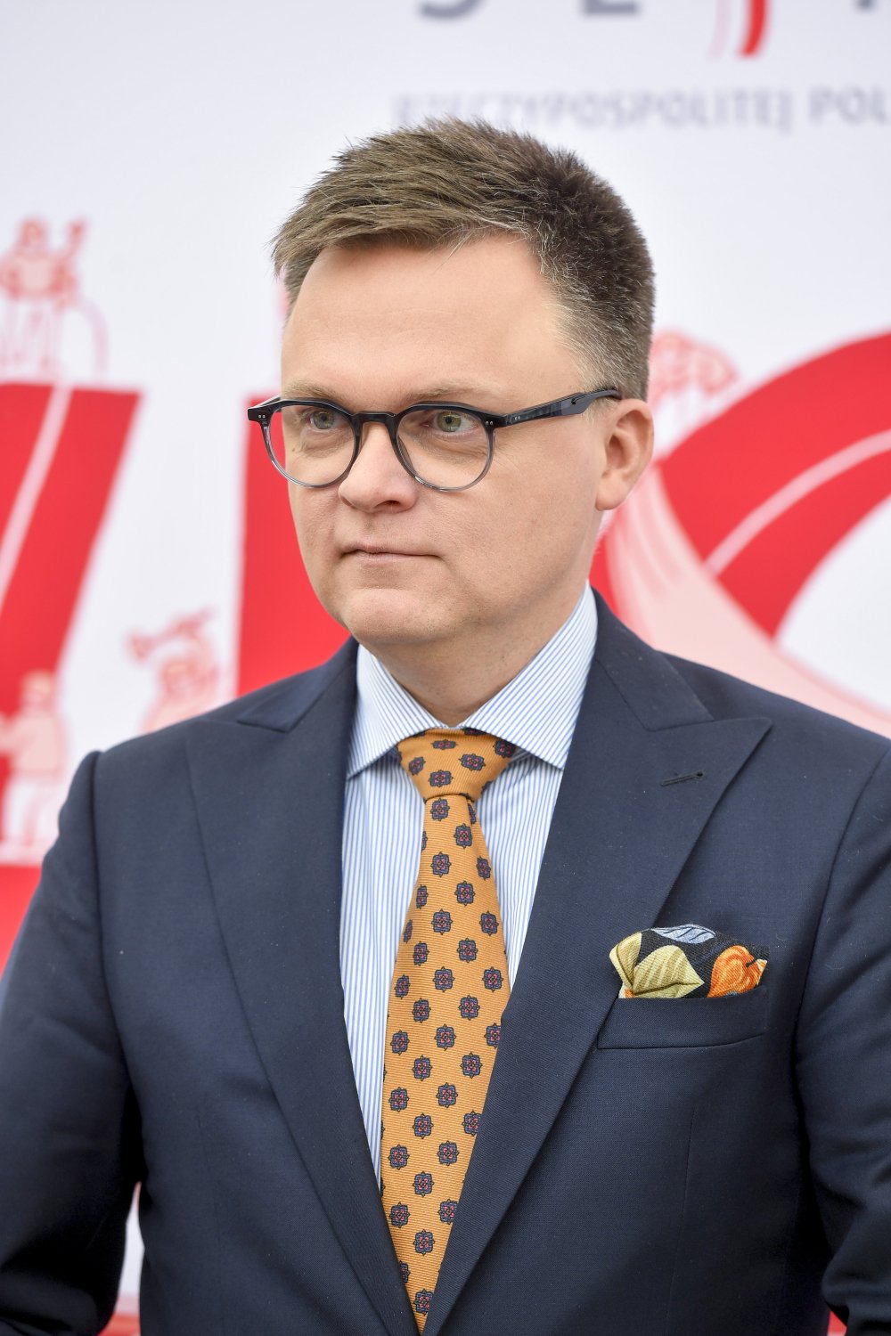 Szymon Hołownia w garniturze i żółtym krawacie