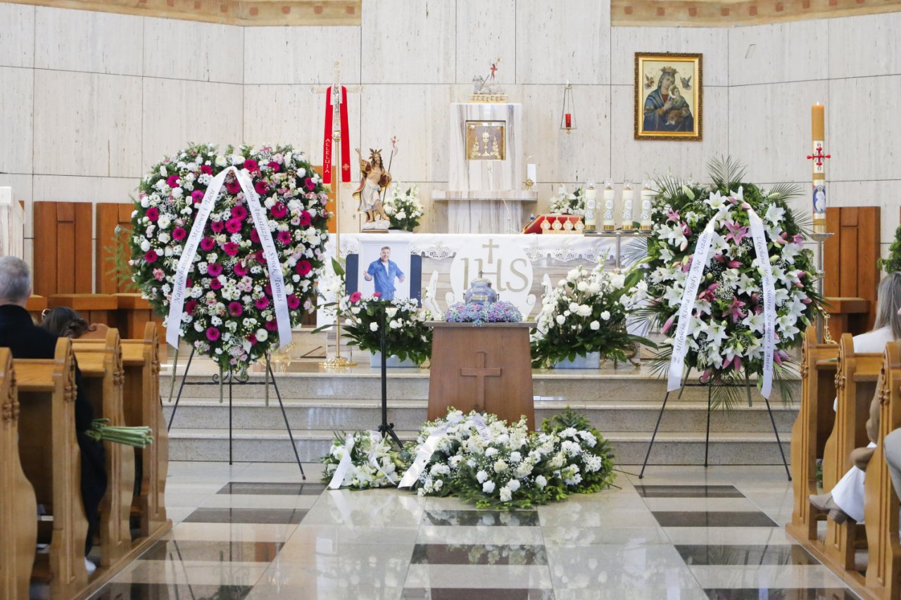urna Tomasza Jakubiaka otoczona kwiatami