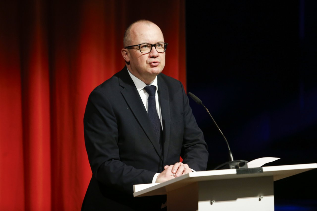 Adam Bodnar przemawia na czerwonym tle podczas pogrzebu Andrzeja Turskiego