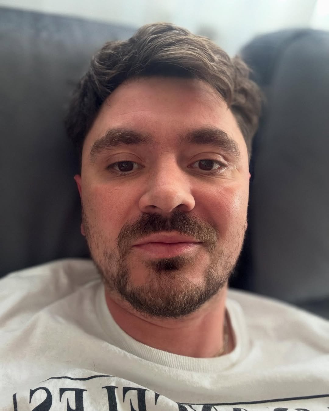 Daniel Martyniuk na szarym fotelu