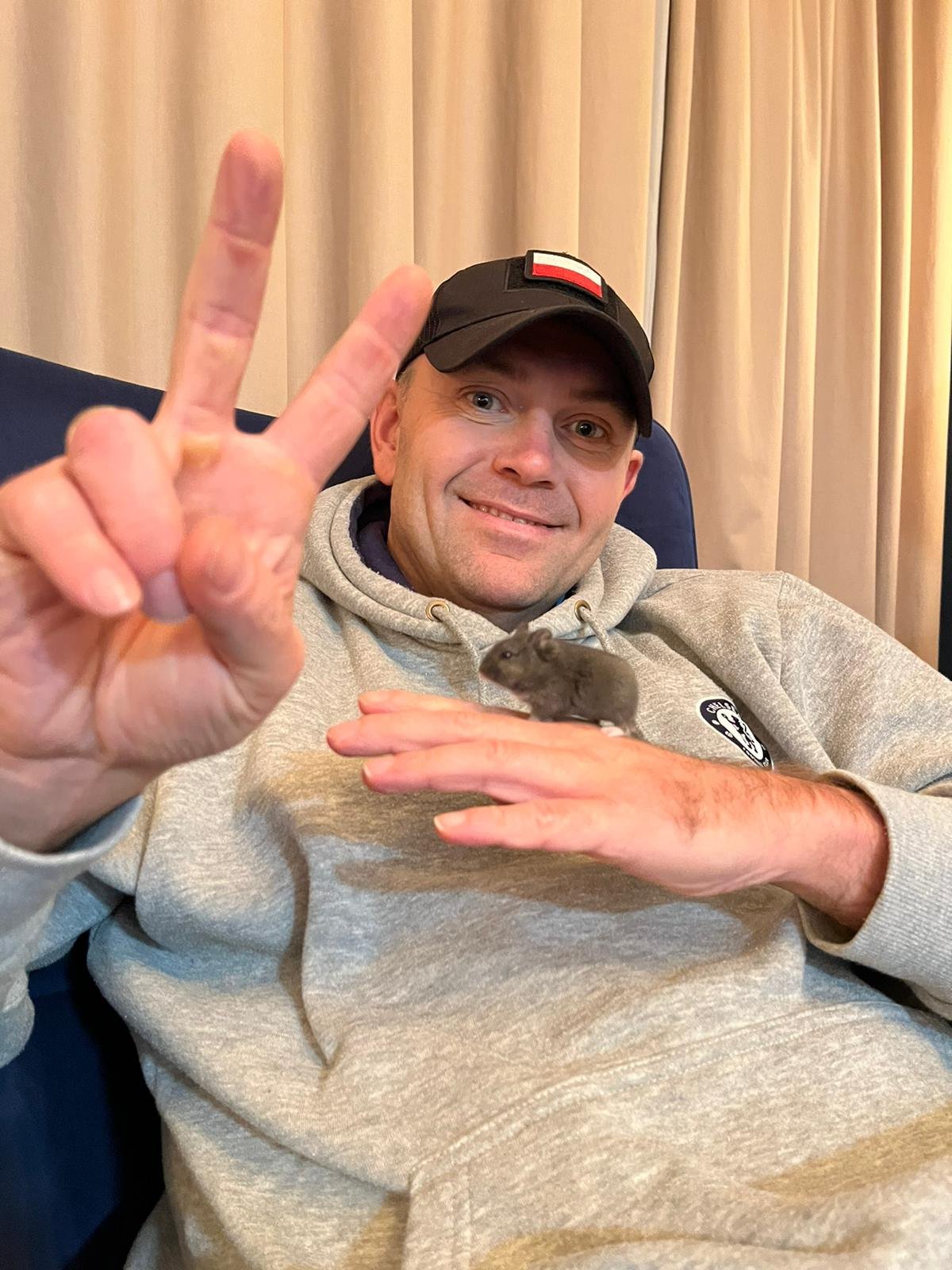 Karol Nawrocki w szarej bluzie i czapce z daszkiem