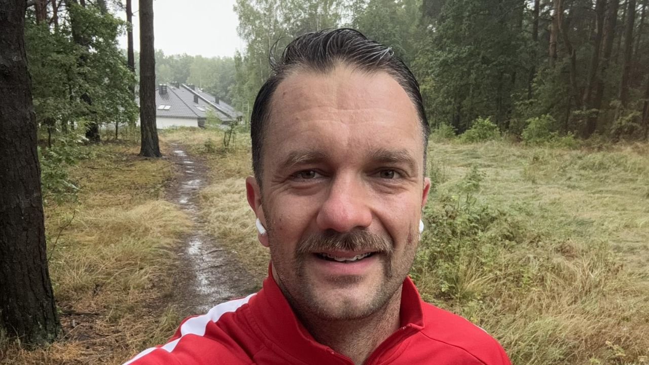 łukasz mejza w czerwonym dresie w czasie joggingu w lesie