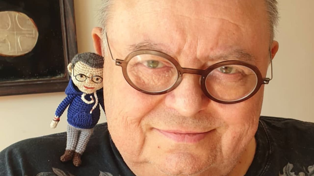 Wojciech Mann z małą laleczką na ramieniu