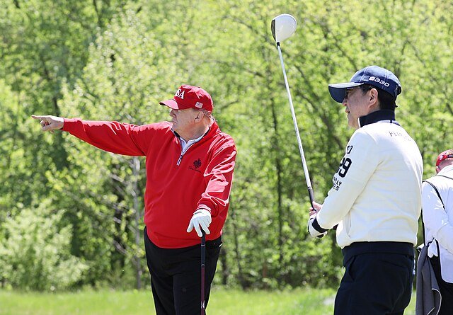 Donald Trump w czapce MAGA na polu golfowym z Shinzo ABe