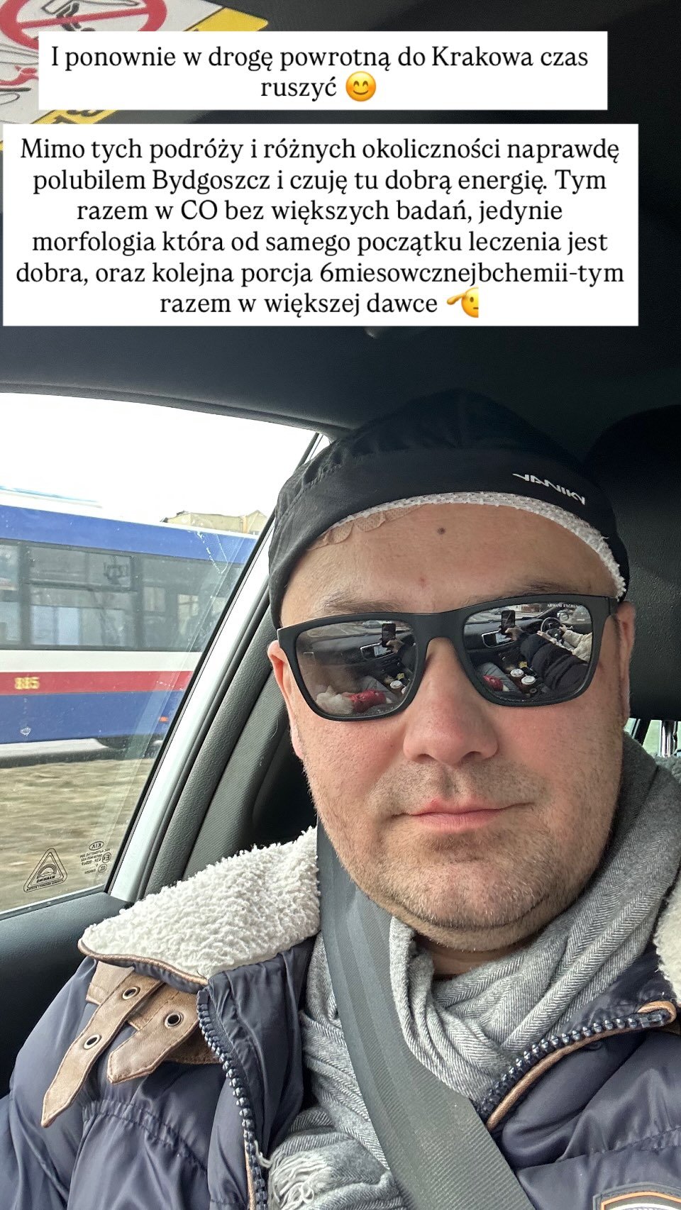 zdjęcie Adriana Szymaniaka w okularach słonecznych, plansza z napisami nad Adrianem