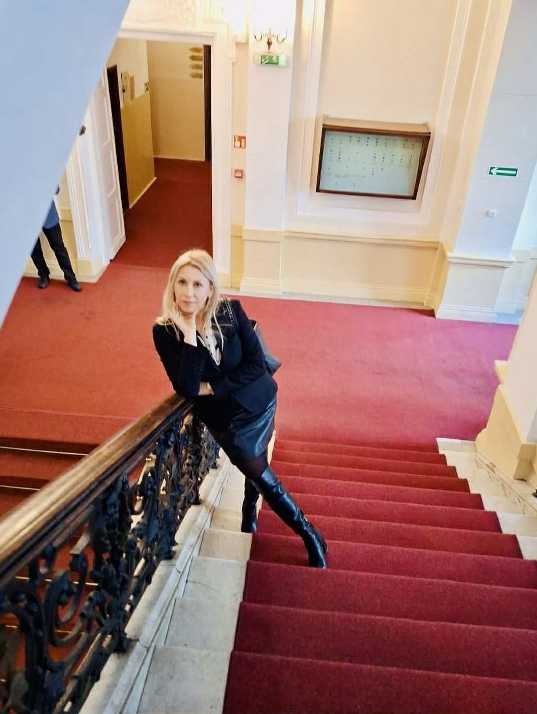 Aldona Błaszczyk Szostak stoi na schodach w czarnej stylizacji