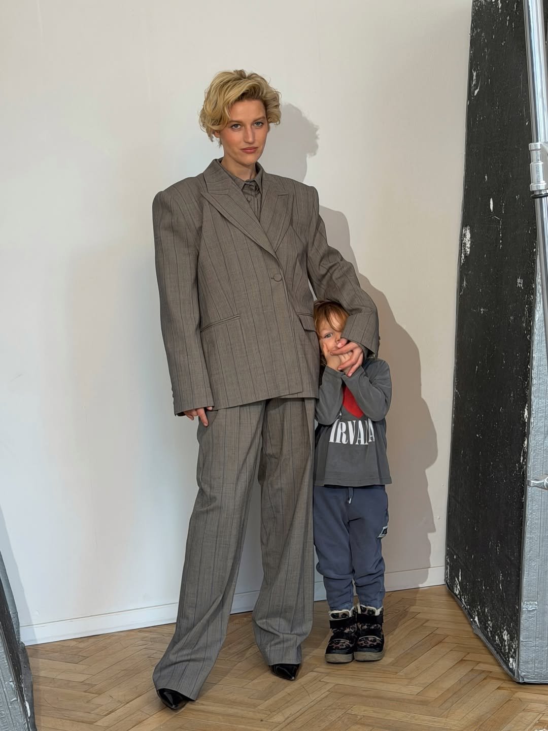 Aleksandra Domańska w szarym garniturze pozuje z synem