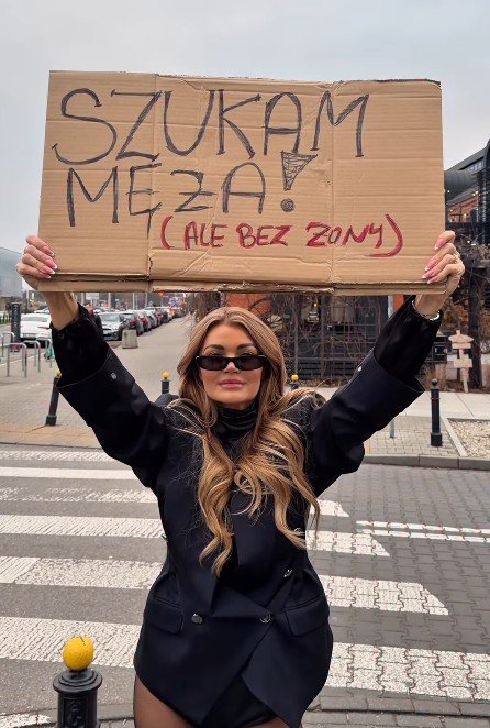 Edyta Folwarska z kartonem z ogłoszeniem w rękach