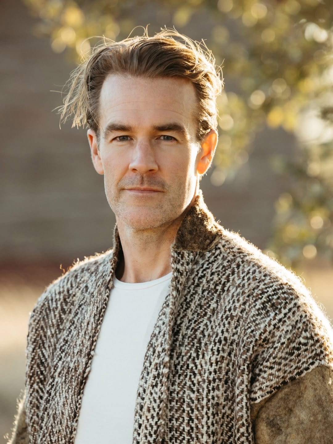 james van der beek w swetrze na tle drzew