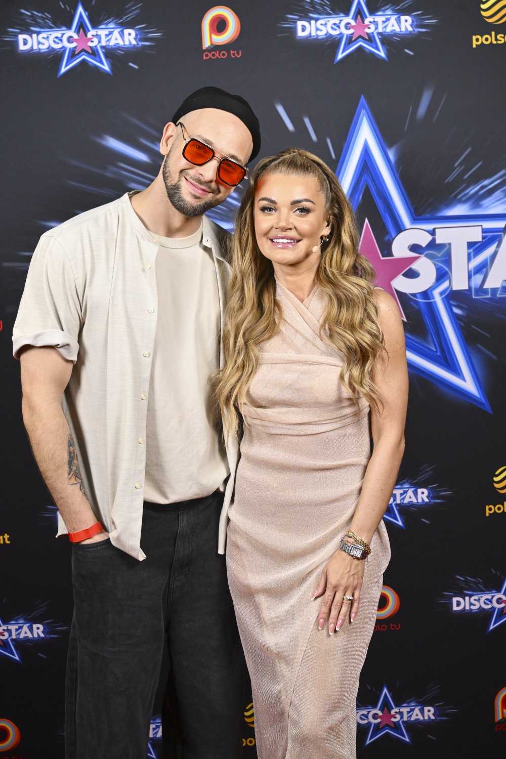 Maciej Pela i Edyta Folwarska w beżowych stylizacjach pozują na ściance Disco Star