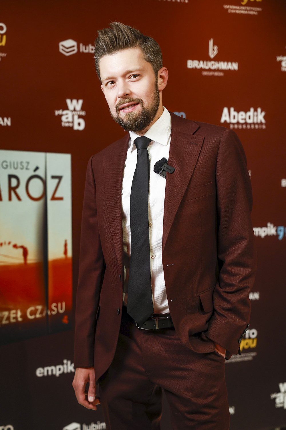 remigiusz mróz w garniturze na ściance