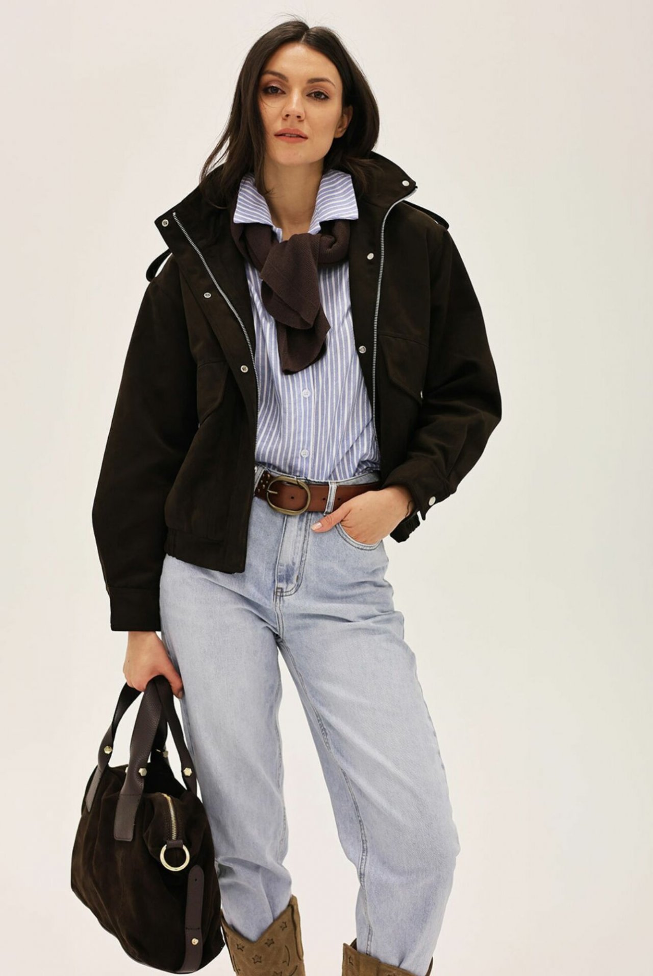 Kobieta ze skórzanymi dodatkami: shopperka, kowbojki, bomberka