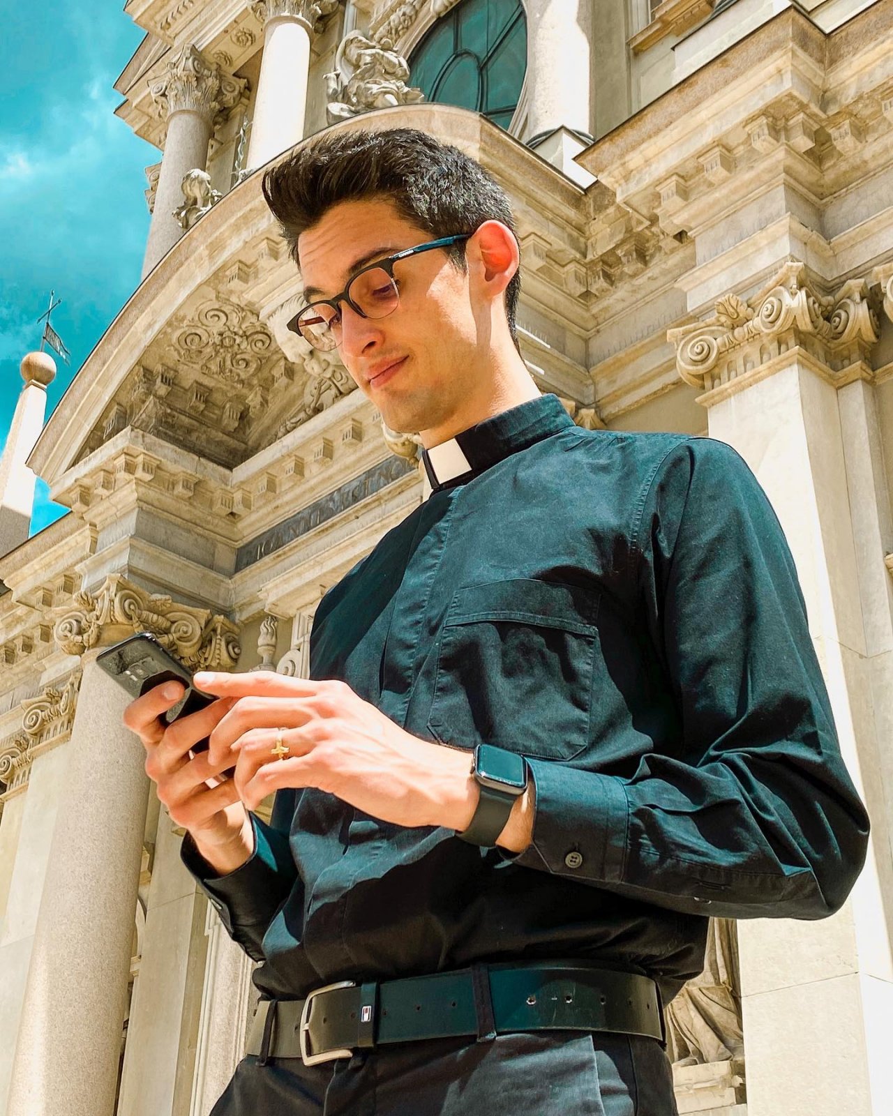 ksiądz patrzący w telefon