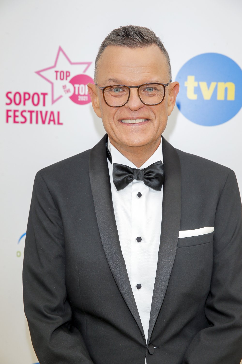 rozesmiany Andrzej Morozowski w czarnej marynarce i muszce