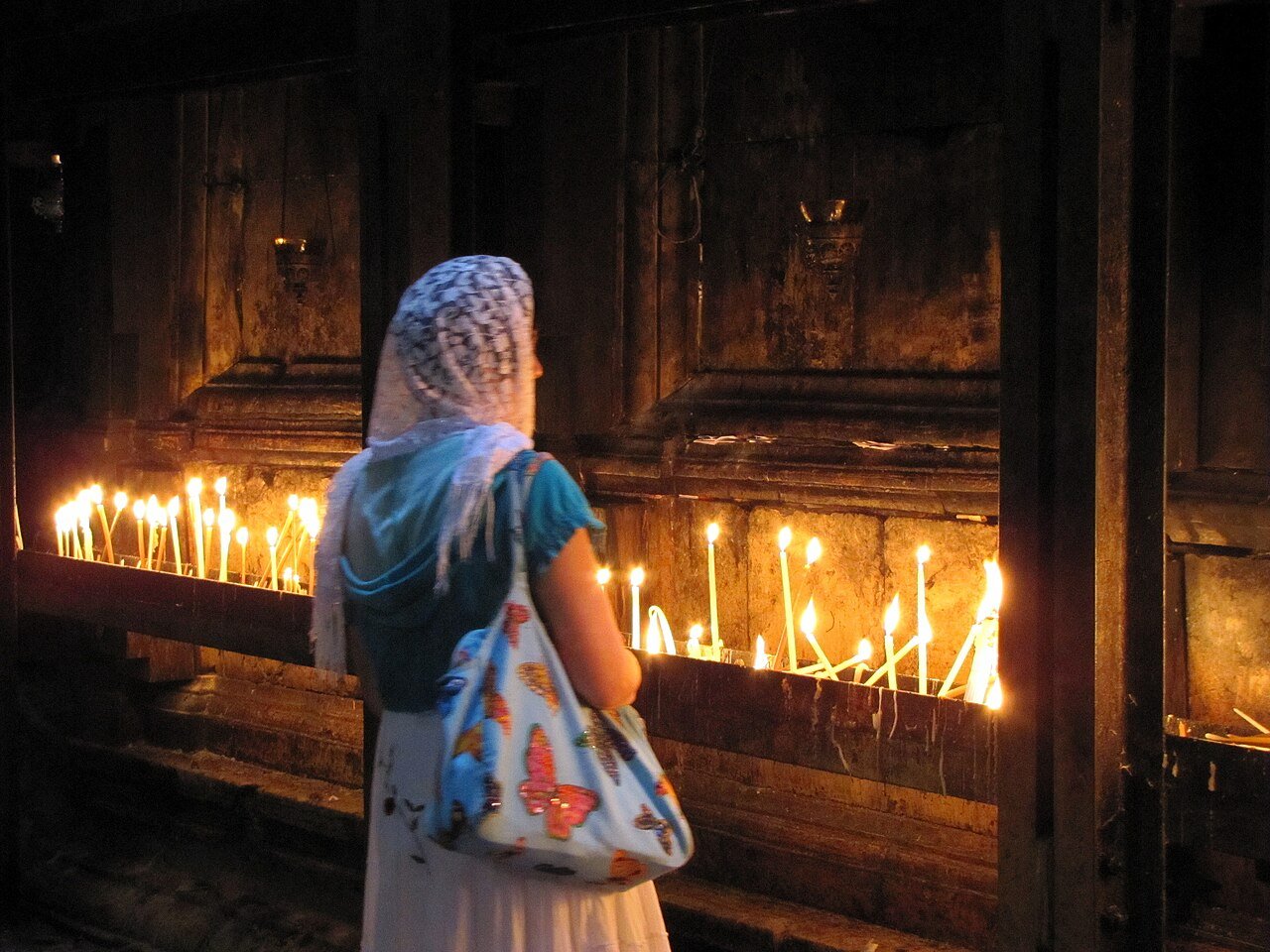 KObieta w czasie modlitwy przy świecach w Bazylika Grobu Świętego, Jerozolima
