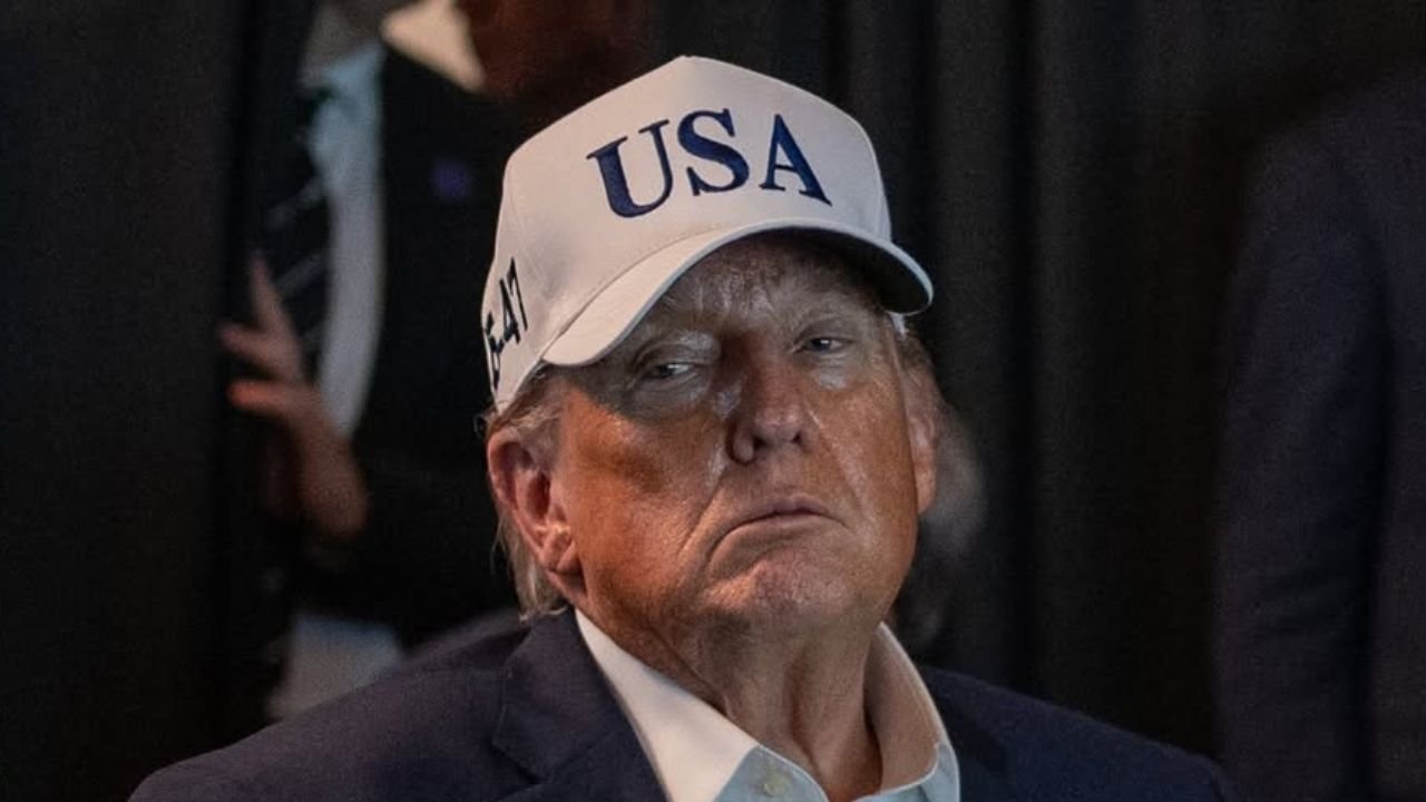 Donald Trump w białej czapce z daszkiem z napisem usa