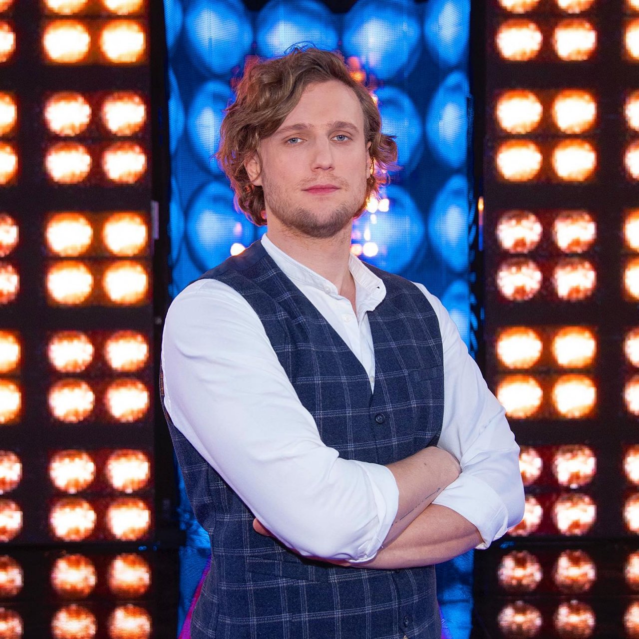 Karol Dziuba w białej koszuli i kraciastej kamizelce