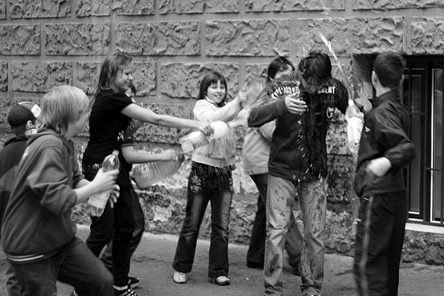 dzieci oblewające się wodą w czasie lanego poniedziałku śmigusa dyngusa