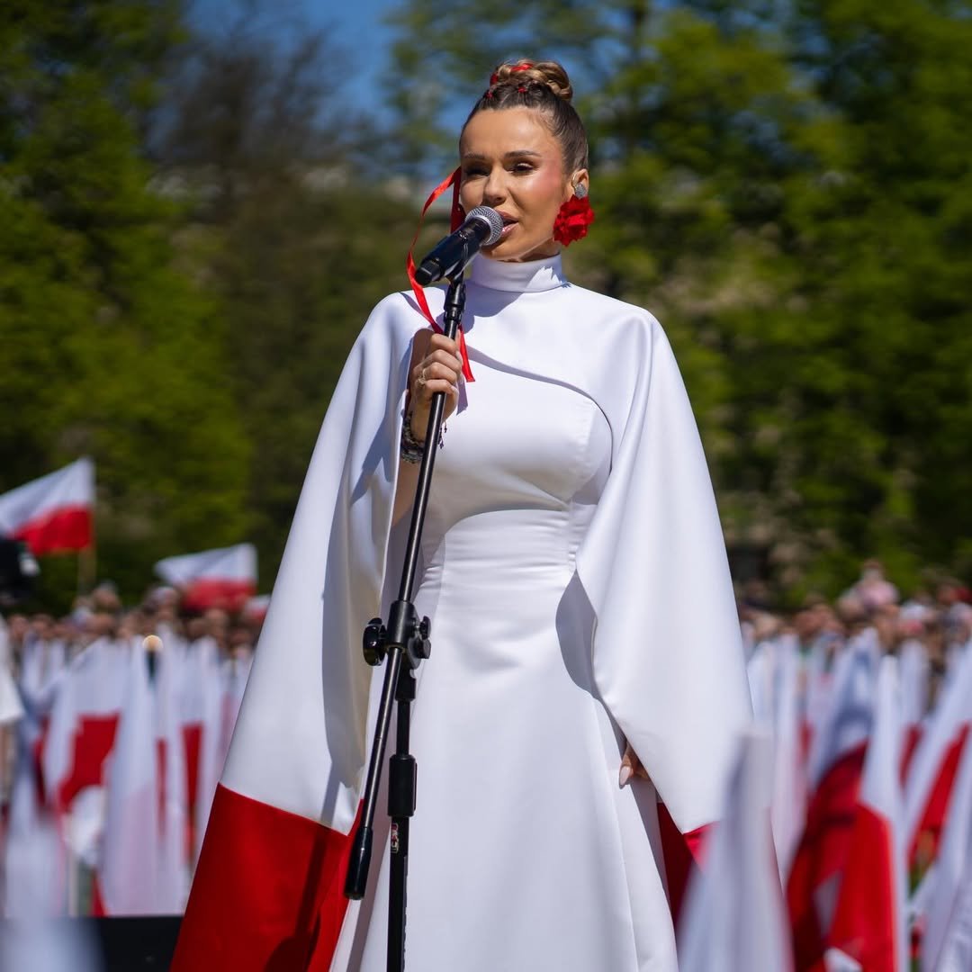 doda w biało czerwonej pelerynie śpiewa hymna polski - święto flagi, błonia kraków