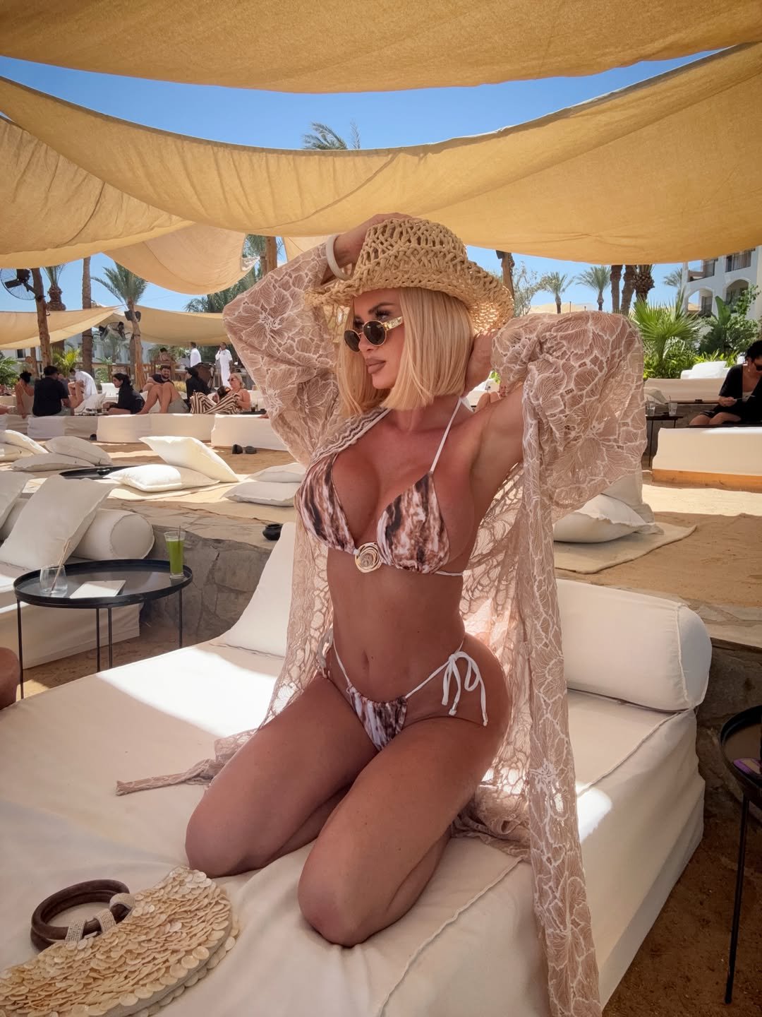 Izabela Macudzińska w kapeluszu, narzutce i bikini pręży się na leżaku