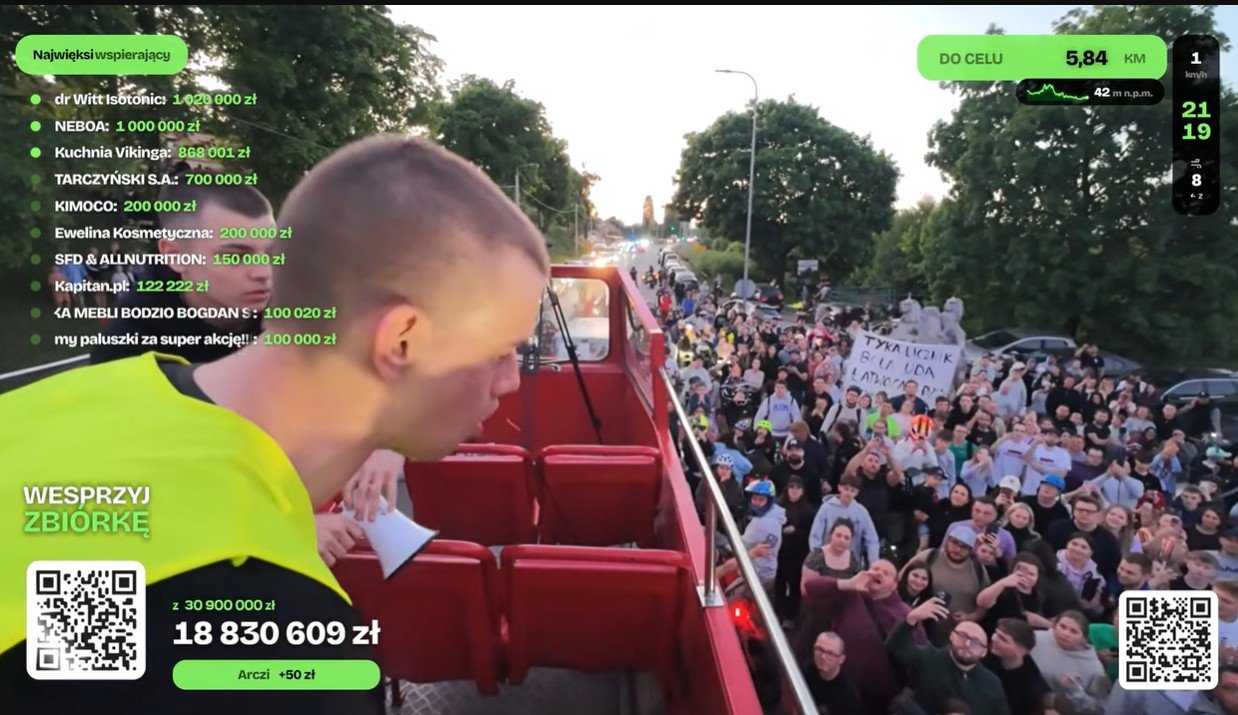 Łatwogang stoi w autobusie, na dole wita go tłum ludzi