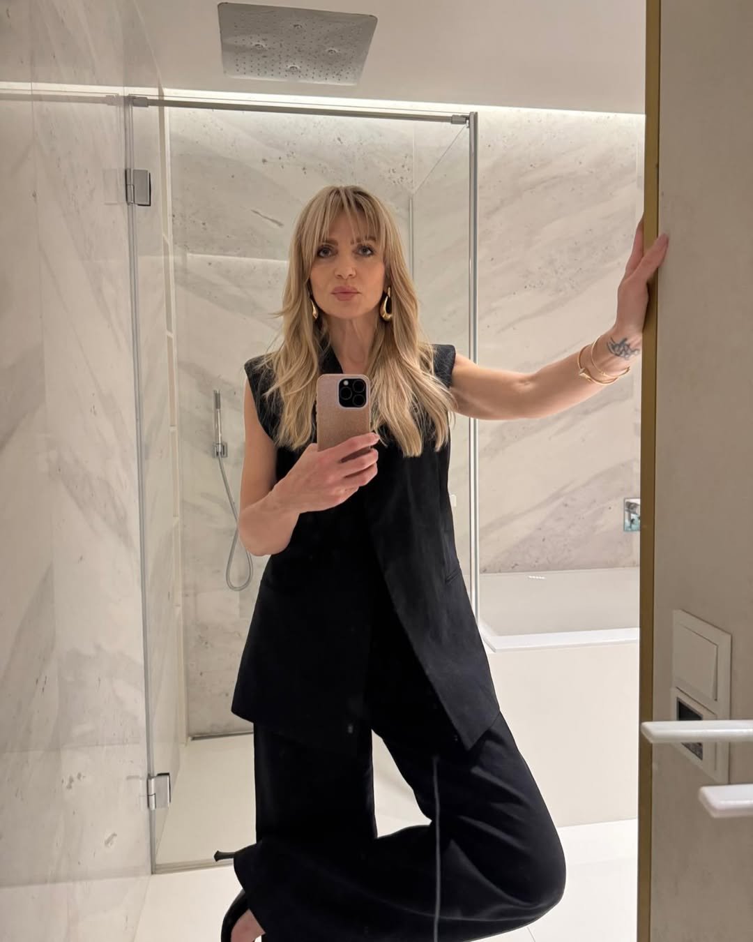 Maja Frykowska, ubrana w czarny komplet robi selfie w lustrze